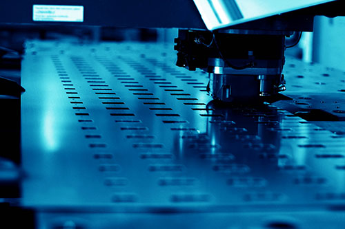 The punching machine is punching the steel plate.